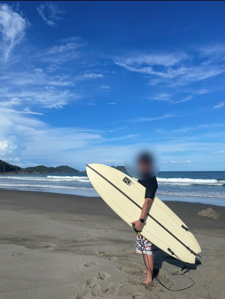 サーフボードを持つA（写真／園田さん提供）